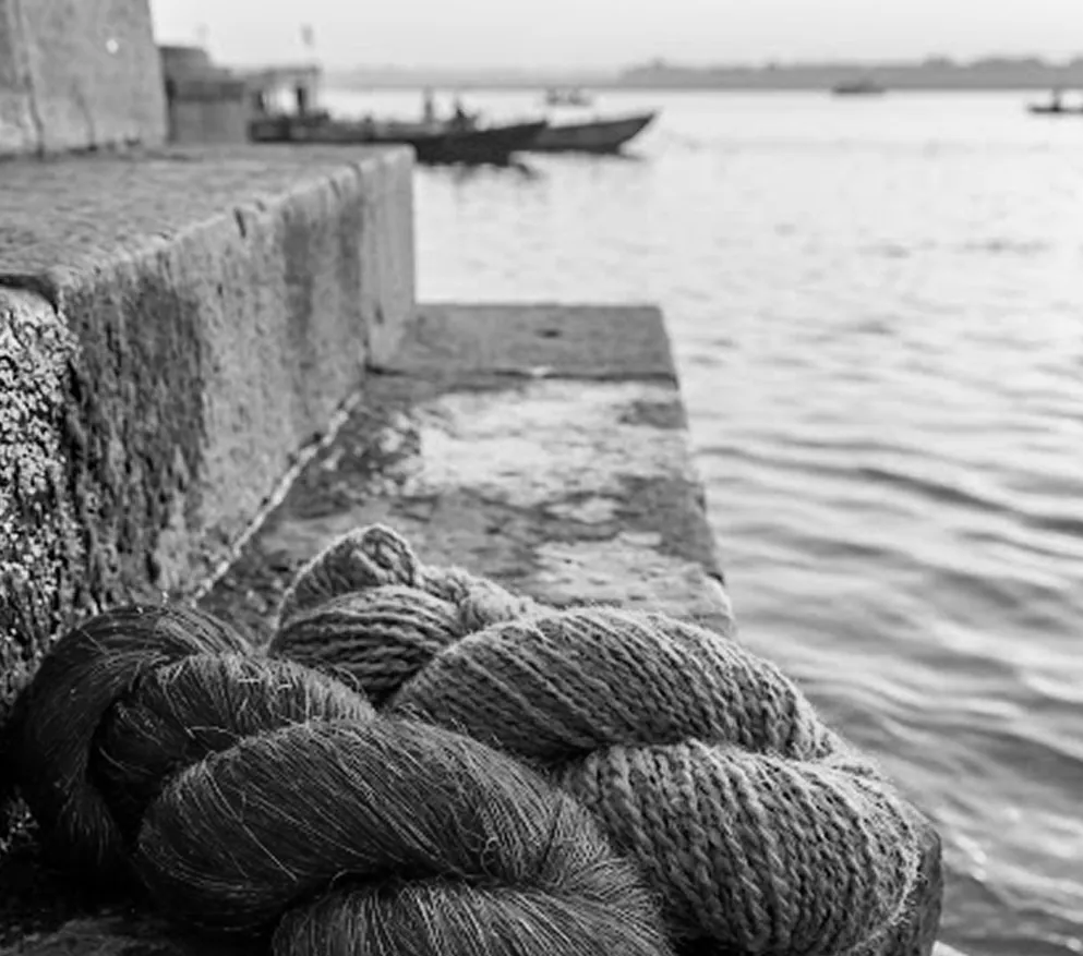 Black and white skeins of wool and silk resting beside the river
